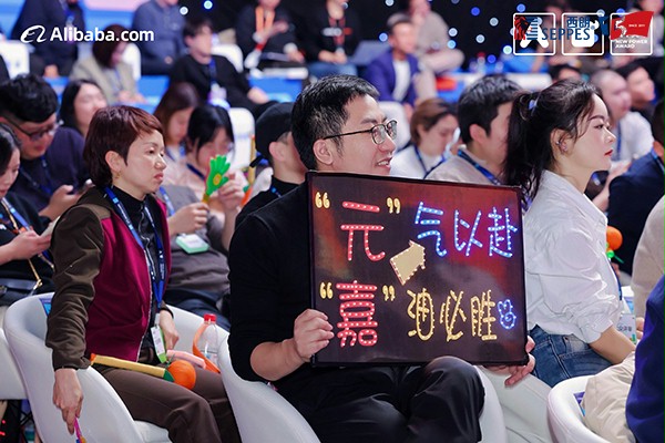 后援团举出“元气以赴，嘉油必胜”的牌子为杨元嘉加油鼓劲